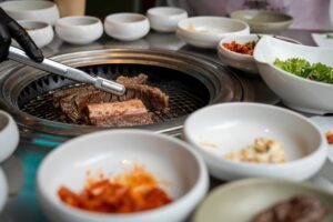 Traditional Korean BBQ grilling with assorted side dishes in Seoul, South Korea.