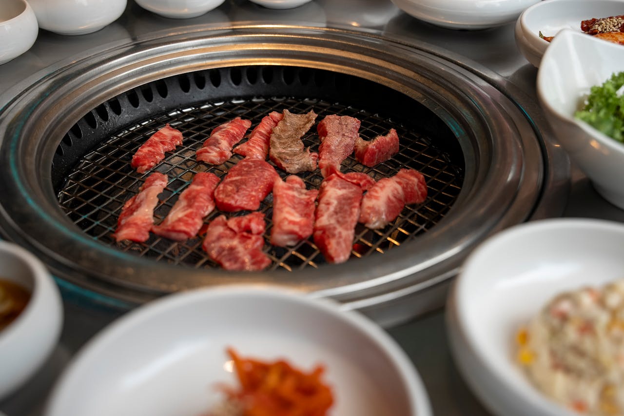 Delicious cuts of beef cooking on a traditional Korean BBQ in Seoul, South Korea.